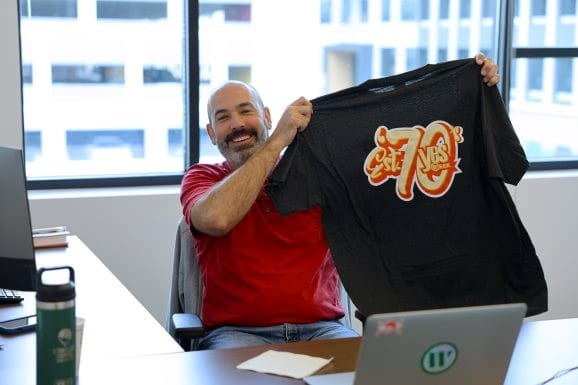 employee holding yes week shirt