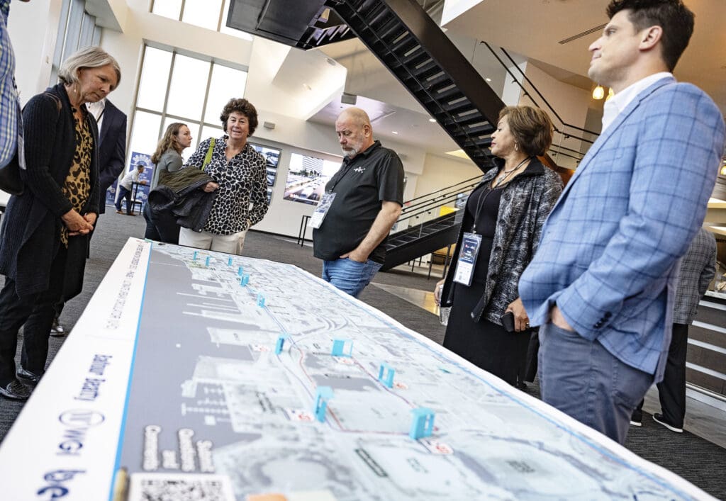 A team gathered around a civil engineering site plan, reviewing project details.