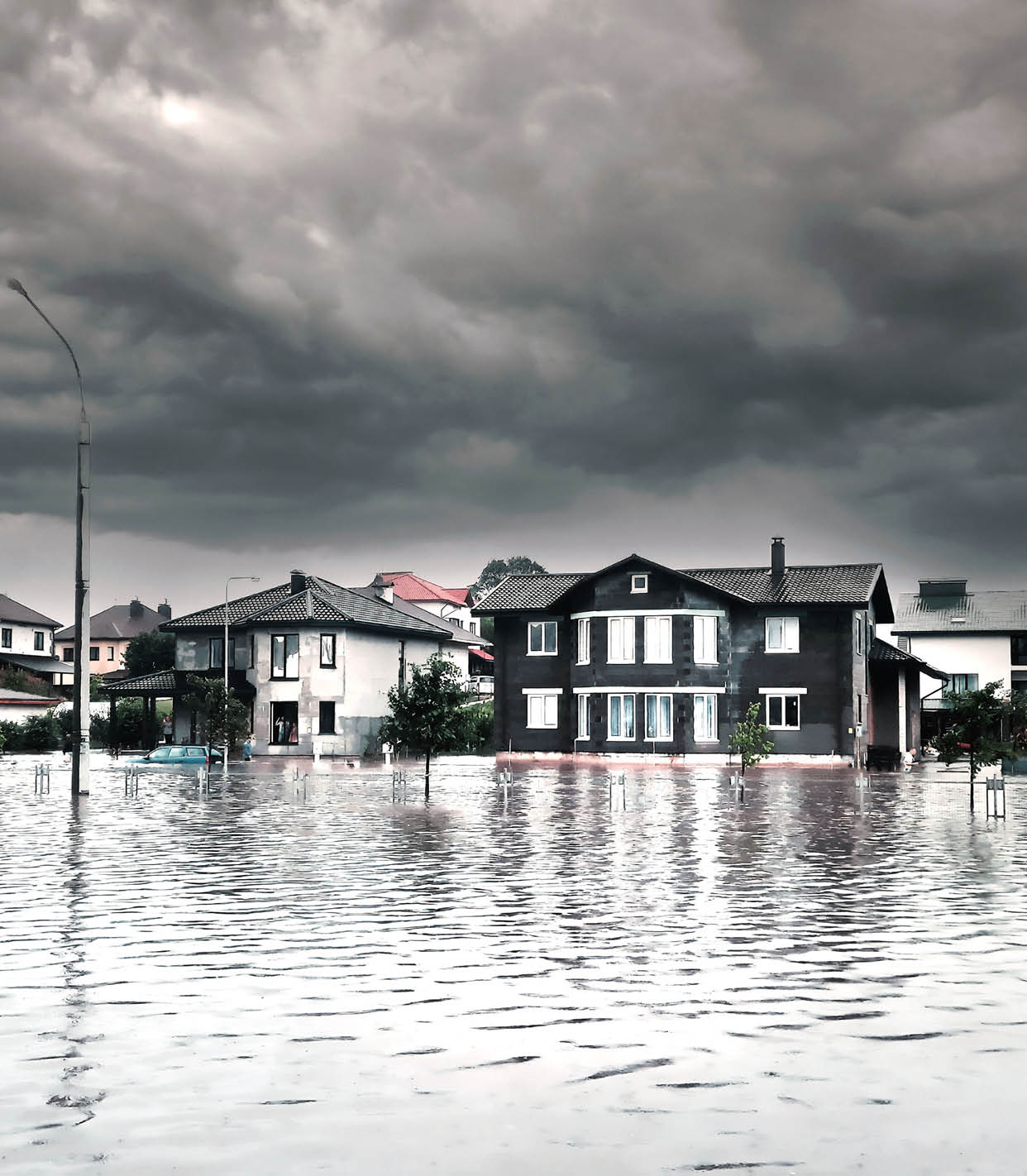 Bad extreme heavy rain storm weather. Flooded streets of the neighborhood. A flooded road junction with a drowned car. Heavy rains from tropical storm caused many flooded areas.